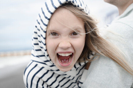 Portrait of screaming girl with her father at the sea