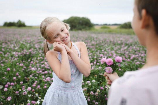 Boy giving a clover flowers to smiling girl