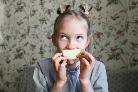Portrait of blond girl with slice of courgette