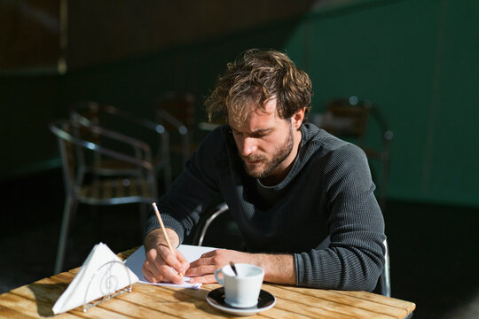 Pensive man sitting in theatre working on script