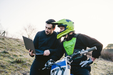 Motocross talking to coach with laptop