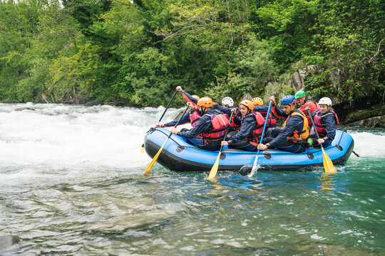 Group of people rafting in rubber dinghy on a river