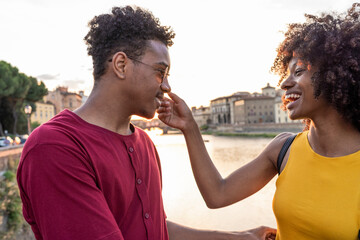 Happy young tourist couple at river Arno at sunset, Florence, Italy