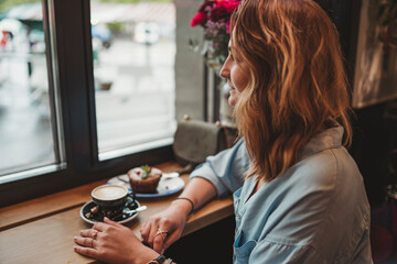 Young woman sitting at the window in a cafe