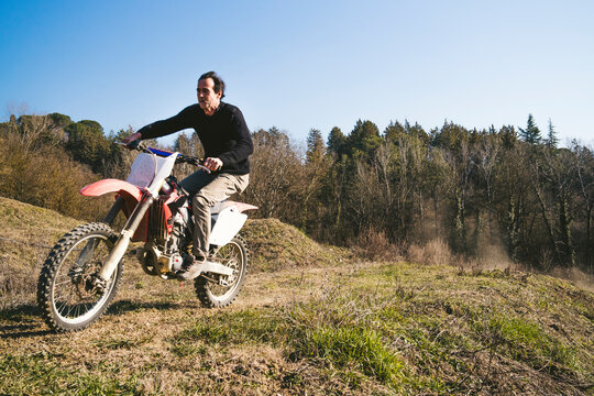 Senior motocross driver riding on circuit