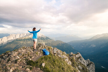 Austria, Tyrol, woman on a hiking trip in the mountains cheering on peak