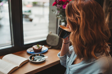 Young woman drinking from coffee cup in a cafe