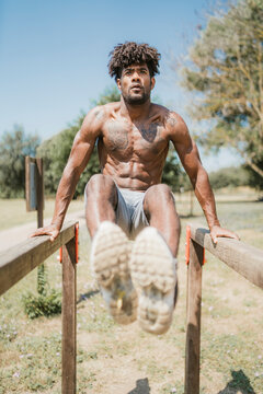 Young man during workout on bars in park