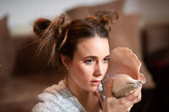 Portrait of young woman with big shell