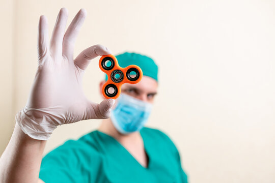 A doctor in a mask and gloves, with a spinner in his hands.