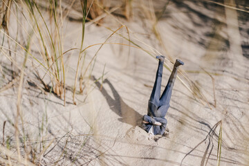 Businessman figurine stuck in sand upside down