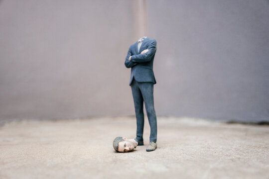 Headless businessman figurine standing on cocrete