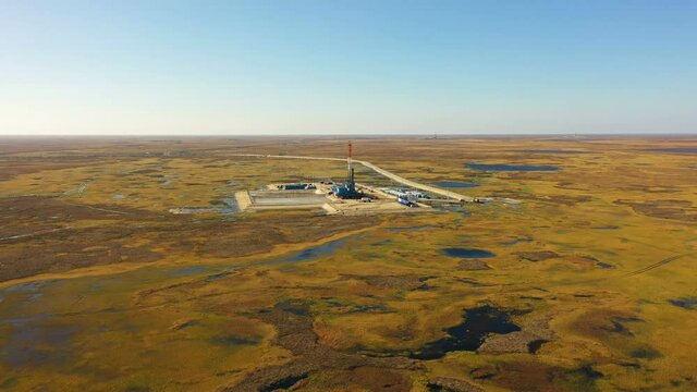 Drilling rigs in tundra. Blue lakes, Red tundra Aerial view. Drilling platform surrounded by lakes and orange fields