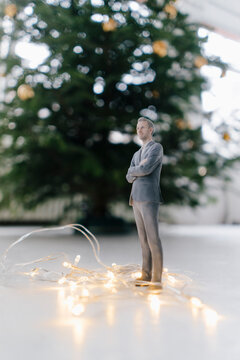 Businessman figurine standing next to a Christmas tree at home