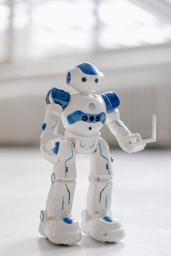 Miniature robot figurine holding laptop