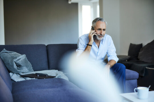 Mature man on the phone at home