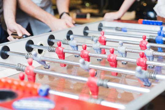 Close-up of colleagues playing foosball in office