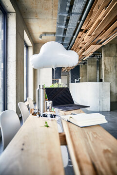 Creative office with cloud balloon and laptop