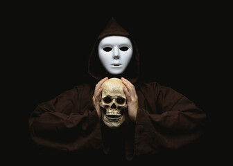 A girl in a scary white mask and brown cultist robe. Holding a skull in her hands. Dark background....
