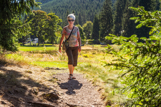 Senior woman hiking on forest path, Oberhof, Thuringia, Germany