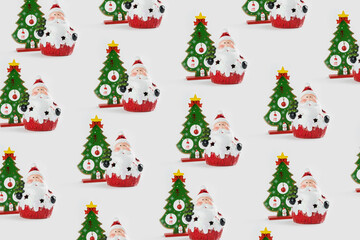 Pattern with Christmas ornaments including Santa Claus and Christmas tree on white background.