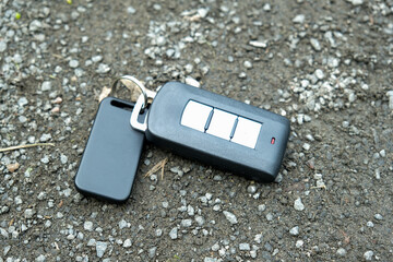 Lost car keys lying on the footpath in a park, somebody dropped auto remote control