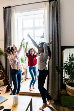 Three women at home having a party and dancing