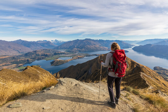 Woman standing on viewpoint at Roys Peak, looking to Mount Aspiring, Lake Wanaka, South Island, New Zealand