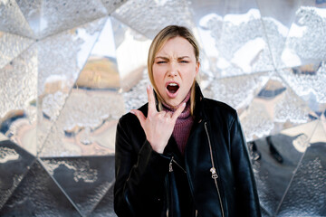 Portrait of screaming young woman showing Rock And Roll Sign