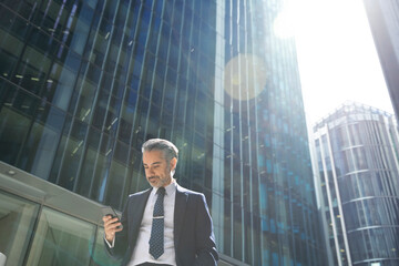 Businessman using smartphone in city