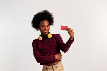 African American girl in brown sweater poses while showing her credit card. - 462724320