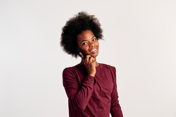 African American girl in brown sweater poses while talking on the phone. - 462724370