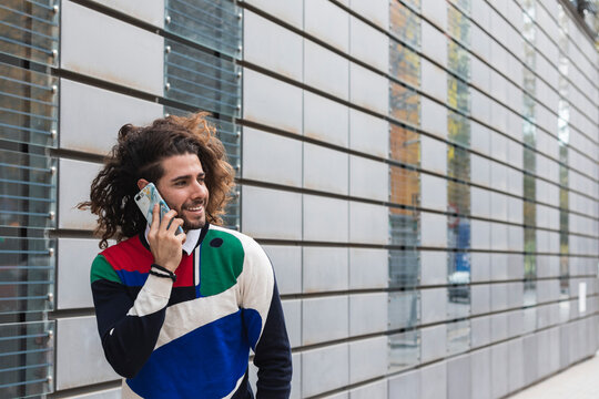 Smiling man talking on smart phone in city