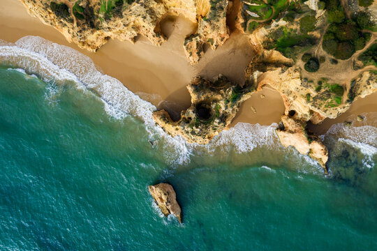 Portugal, Algarve, Alvor, Drone view of sandstone cliffs and beach at Praia dos Tres Irmaos