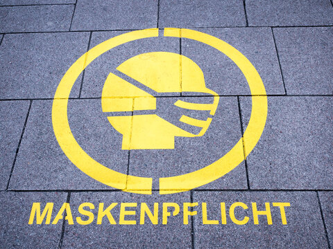 Coronavirus related wear a mask sign on sidewalk