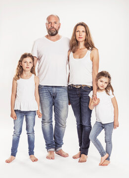Portrait of family with two daughters standing in front of white background