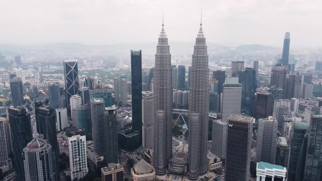 A cinematic drone shot of the Kuala Lumpur City Center twin tower in 4K