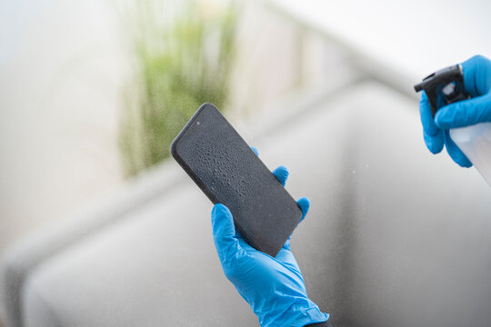 Close-up of woman disinfecting cell phone