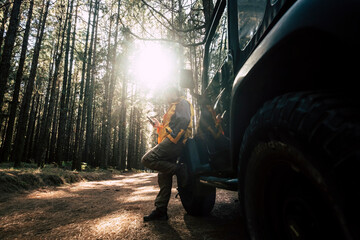 Man using mobile phone while leaning on car in forest at El Teide National Park, Tenerife, Spain
