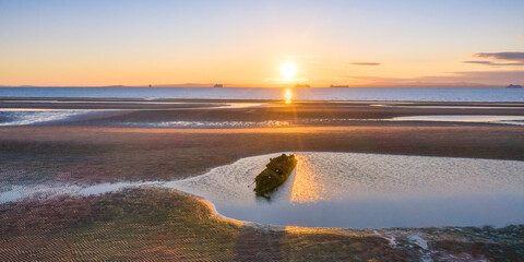 UK, Scotland, Wreck of X-Craft submarine lying on shore of Aberlady Bay at sunset