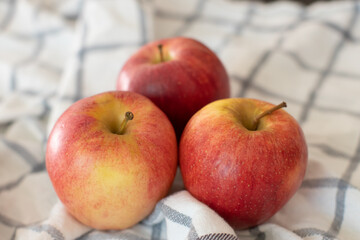 Three Red Gala Apples on a Plaid Ivory Cloth in the Kitchen