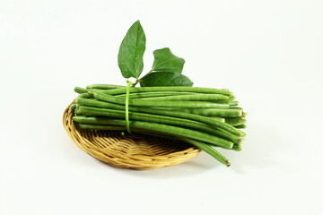 fresh indian vegetable green long beans or black eye pea in bamboo basket in white background