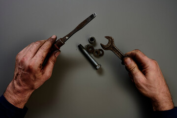 Top view of hand with tools in front of grey background