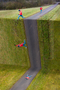 Young male sportsperson fallen on road while jumping over abyss