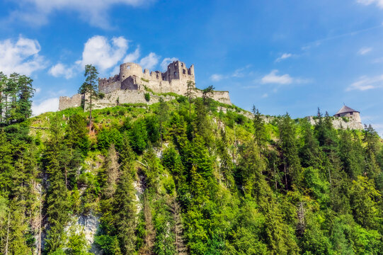 Austria, Tyrol, Reutte, Ruins of Ehrenberg Castle standing on top of forested hill in summer