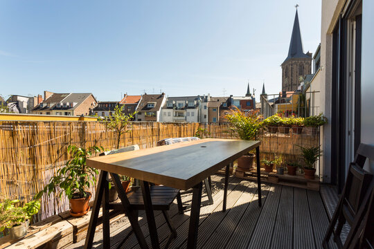 Table on apartment balcony covered with straw mats
