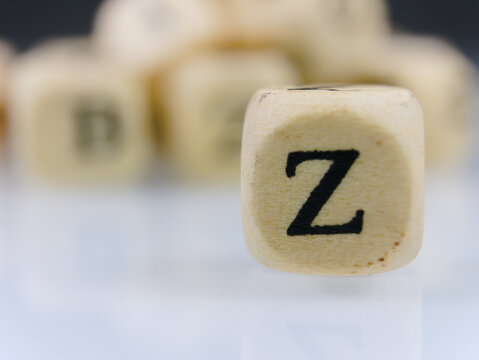 Selective focus a small wooden dice with an uppercase alphabet letter Z on a white table