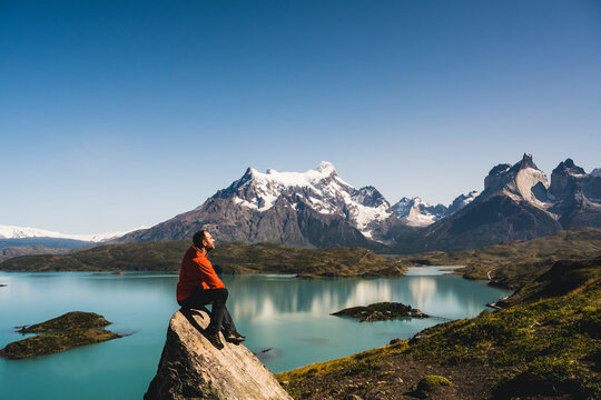 Man sitting on rock at Lake Pehoe in Torres Del Paine National Park, Chile Patagonia, South America