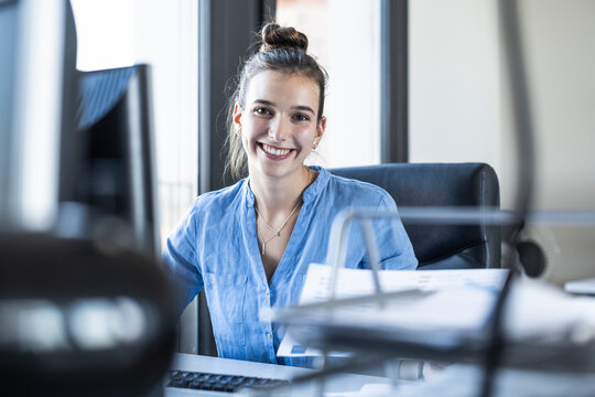 Smiling businesswoman sitting at office