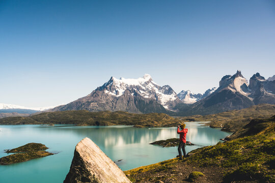 Man looking at Lake Pehoe through binocular in Torres Del Paine National Park, Chile Patagonia, South America